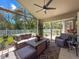 Relaxing sunroom with wicker furniture, ceiling fan, and views of the fenced backyard at 13627 Glaze Brook Dr, Hudson, FL 34667