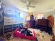 Cluttered bedroom featuring a ceiling fan and two windows at 13730 Coco Ave, Hudson, FL 34667