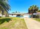 Charming single-story home with a clean driveway and two palm trees in the front yard at 13730 Coco Ave, Hudson, FL 34667