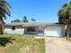 Well lit single-story home with a clean driveway and low stone garden barrier on front of home at 13730 Coco Ave, Hudson, FL 34667