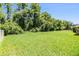 A spacious backyard with a lush lawn and mature trees offers privacy at 1418 Halapa Way, Trinity, FL 34655