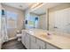 Bright bathroom with a large mirror, white cabinets, and modern fixtures at 1418 Halapa Way, Trinity, FL 34655