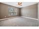 This bedroom boasts neutral walls, a ceiling fan, and a large window at 1418 Halapa Way, Trinity, FL 34655