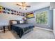 Cozy bedroom featuring a ceiling fan, a comfortable bed, and wall decor and a window at 1418 Halapa Way, Trinity, FL 34655