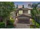 Charming two-story home featuring a brick driveway, two-car garage, and landscaped yard at 1418 Halapa Way, Trinity, FL 34655