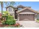 Two-story home with a two car garage, arched entryway, and well-maintained landscaping at 1418 Halapa Way, Trinity, FL 34655