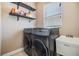 A bright laundry room with shelving above the washer and dryer and a utility sink at 1418 Halapa Way, Trinity, FL 34655