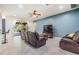 Open-concept living room with tile floors, a ceiling fan, and leather sofas at 1418 Halapa Way, Trinity, FL 34655