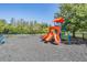 Community playground features colorful slides and climbing structures, surrounded by a black fence at 1418 Halapa Way, Trinity, FL 34655