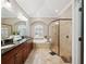 Bathroom featuring double sinks, garden tub, and glass-enclosed shower at 15413 Azra Dr, Odessa, FL 33556