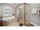 Bright bathroom features a large glass shower and soaking tub near a window at 15413 Azra Dr, Odessa, FL 33556