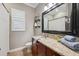 Bathroom with a granite countertop, dark wood cabinets, and a framed mirror at 15413 Azra Dr, Odessa, FL 33556