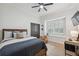 Comfortable bedroom features a ceiling fan, window shutters, and wood-look flooring at 15413 Azra Dr, Odessa, FL 33556