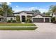 Stunning single-story home with a manicured lawn, mature landscaping, and a three-car garage at 15413 Azra Dr, Odessa, FL 33556