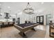 Open-concept space featuring a pool table and modern chandelier with access to a kitchen and dining area at 15413 Azra Dr, Odessa, FL 33556
