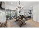 Bright living room with a pool table, sliding glass doors, and open to kitchen at 15413 Azra Dr, Odessa, FL 33556