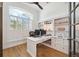 Bright office with white built-in shelving, an L-shaped desk, and plantation shutters at 15413 Azra Dr, Odessa, FL 33556