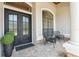 Inviting front porch with tiled flooring, seating, and a decorative front door at 15413 Azra Dr, Odessa, FL 33556
