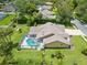 Overhead view of the property displaying the backyard, screened-in pool, and well-manicured landscaping at 18244 Autumn Lake Boulevard, Hudson, FL 34667