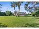 Expansive backyard showcases a well-maintained lawn, mature trees, and a screened-in pool enclosure at 18244 Autumn Lake Boulevard, Hudson, FL 34667