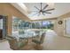 Screened-in patio features a ceiling fan and a glass table with comfortable cushioned seating near the refreshing pool at 18244 Autumn Lake Boulevard, Hudson, FL 34667