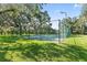 Fully fenced basketball court surrounded by trees and green space at 18244 Autumn Lake Boulevard, Hudson, FL 34667