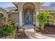 Inviting entryway with blue double doors, tiled walkway, and well-maintained landscaping at 18244 Autumn Lake Boulevard, Hudson, FL 34667