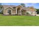 Beautiful home featuring a manicured lawn, arched windows, and a two-car garage at 18244 Autumn Lake Boulevard, Hudson, FL 34667