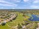 Stunning aerial view of a lush golf course community with lakes and beautiful blue skies at 18520 Hidden Pines Way, Hudson, FL 34667