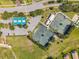 Aerial view showcasing tennis courts, parking, and green spaces within a well-maintained community at 18520 Hidden Pines Way, Hudson, FL 34667