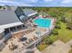 Aerial view of community pool, hot tub, lounge area, and clubhouse, enhanced by lush landscaping and attractive design at 18520 Hidden Pines Way, Hudson, FL 34667