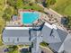 Aerial view of a community pool, hot tub, lounge area, and clubhouse with gray roof and lush landscaping at 18520 Hidden Pines Way, Hudson, FL 34667