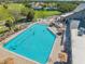 Aerial view showcases the pool area with a large pool, seating, and beautiful green surroundings at 18520 Hidden Pines Way, Hudson, FL 34667