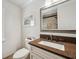 A well-lit bathroom featuring a vanity with granite countertop, framed mirror and modern fixtures for added comfort at 18520 Hidden Pines Way, Hudson, FL 34667