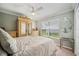 A bright bedroom with a large window, a decorative mirror, and a spacious wardrobe at 18520 Hidden Pines Way, Hudson, FL 34667