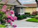 Beautiful landscaping surrounds the walkway to this lovely home with an arched window at 18520 Hidden Pines Way, Hudson, FL 34667