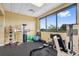 Brightly lit gym with exercise equipment and large window showcasing the exterior view at 18520 Hidden Pines Way, Hudson, FL 34667