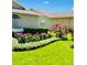 Beautifully landscaped yard with flowering plants, manicured bushes, and lush green grass at 18520 Hidden Pines Way, Hudson, FL 34667