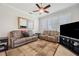 Cozy living room with a large TV, comfortable seating, and natural light through the windows at 18520 Hidden Pines Way, Hudson, FL 34667