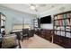 A bright home office featuring a large window, a dark wood desk, and built-in storage for a productive work environment at 18520 Hidden Pines Way, Hudson, FL 34667