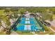 Aerial view of pickleball courts with players in action, surrounded by trees and parking at 18520 Hidden Pines Way, Hudson, FL 34667