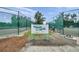 Tennis court entrance featuring the sign, Heritage Pines Tennis Courts, with gated courts in the background at 18520 Hidden Pines Way, Hudson, FL 34667