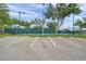 Outdoor tennis courts with blue surface, surrounded by greenery, accessible from paved parking lot at 18520 Hidden Pines Way, Hudson, FL 34667