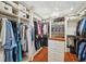 Spacious walk-in closet with custom shelves, drawers, wood floor, and stylish chandelier at 18520 Hidden Pines Way, Hudson, FL 34667