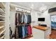 Large walk-in closet featuring custom storage, wood floors, desk, and access to Primary bedroom at 18520 Hidden Pines Way, Hudson, FL 34667