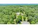 Aerial view of a large property with a house, detached garage and screened pool on a sunny day at 21000 Exeter Ct, Brooksville, FL 34601