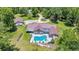 Aerial view of large property with a house, screened pool, and a matching detached garage at 21000 Exeter Ct, Brooksville, FL 34601