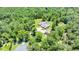Aerial view of a large property with a house, detached garage and screened pool surrounded by tall trees at 21000 Exeter Ct, Brooksville, FL 34601