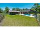 A fenced-in yard features a screened pool, a patio area, and luscious green landscaping at 21000 Exeter Ct, Brooksville, FL 34601