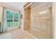 Modern bathroom showcases a frameless glass shower enclosure, tile flooring, and a large window at 21000 Exeter Ct, Brooksville, FL 34601